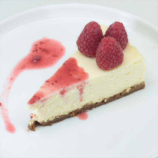 Cremiges Himbeer-Cheesecake-Stück mit hausgemachtem Beeren-Coulis von Dessert at Home