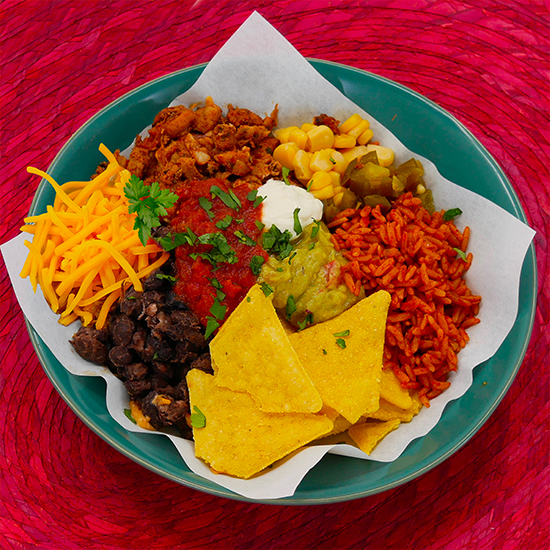 Üppig gefüllte mexikanische Burrito Bowl von Gringos mit Nachos, Guacamole, Bohnen und Reis