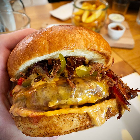 Hausgemachter Gourmet-Burger mit frischen Toppings vom Restaurant La Manufacture Basel